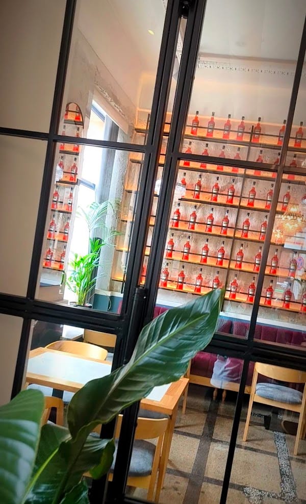 Bar z butelkami Aperol za szybą Crittall